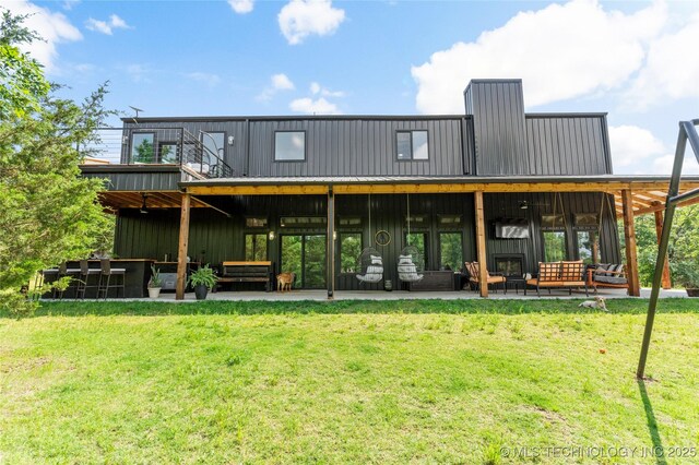 8562 Adams Creek Rd, Beggs, OK 74421 - rear view of property featuring a lawn, board and batten siding, a patio, and outdoor lounge area