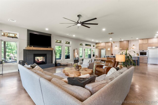 8562 Adams Creek Rd, Beggs, OK 74421 - living room with finished concrete floors, recessed lighting, a fireplace, ceiling fan, and baseboards