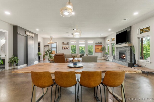 8562 Adams Creek Rd, Beggs, OK 74421 - dining area featuring finished concrete floors, a fireplace, baseboards, recessed lighting, and a chandelier