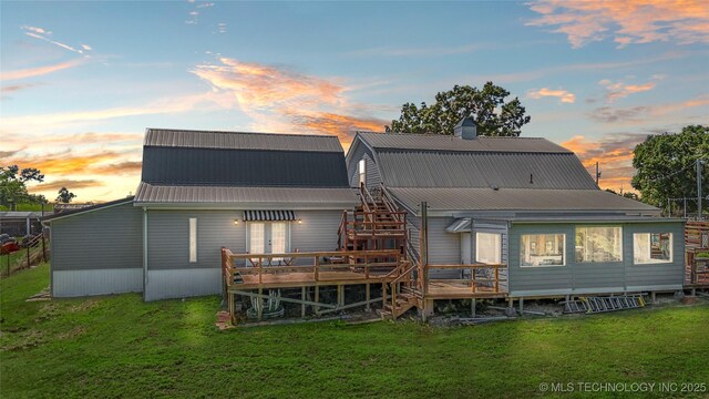 168 Murray Ln, Strang, OK 74367 - back of property at dusk with a wooden deck, a yard, metal roof, and a chimney