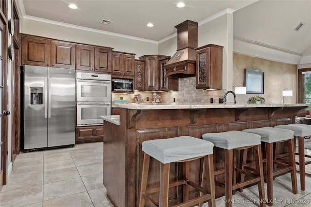 3501 W Gary St S, Broken Arrow, OK 74012 - kitchen featuring appliances with stainless steel finishes, custom range hood, a breakfast bar, backsplash, and crown molding