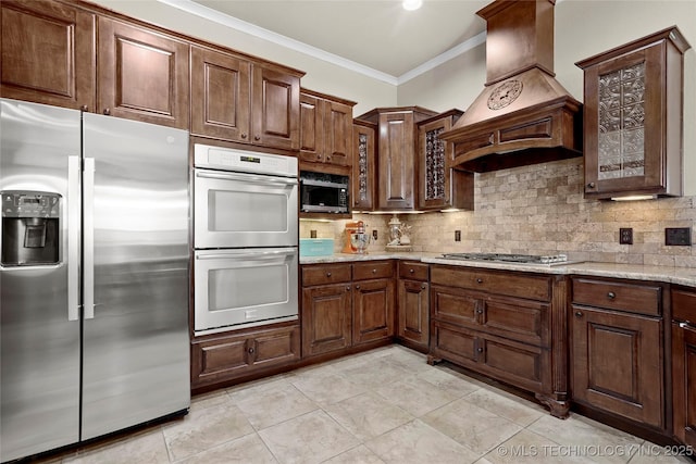 3501 W Gary St S, Broken Arrow, OK 74012 - kitchen with appliances with stainless steel finishes, custom range hood, ornamental molding, backsplash, and light stone counters