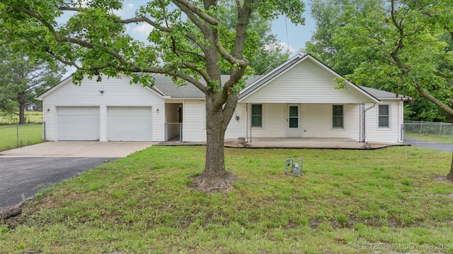 915 N Boudinot Ave, Dewey, OK 74029 - view of front of property featuring asphalt driveway, covered porch, and an attached garage