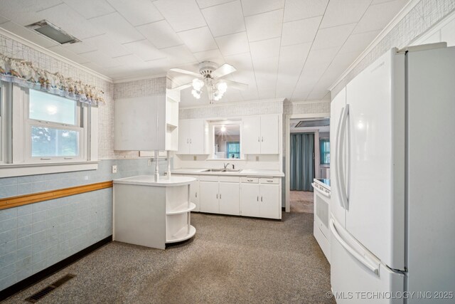 915 N Boudinot Ave, Dewey, OK 74029 - kitchen with white appliances, ceiling fan, light countertops, white cabinets, and crown molding