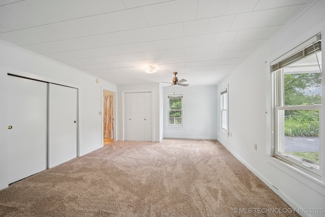 915 N Boudinot Ave, Dewey, OK 74029 - unfurnished bedroom featuring carpet floors, two closets, multiple windows, and crown molding