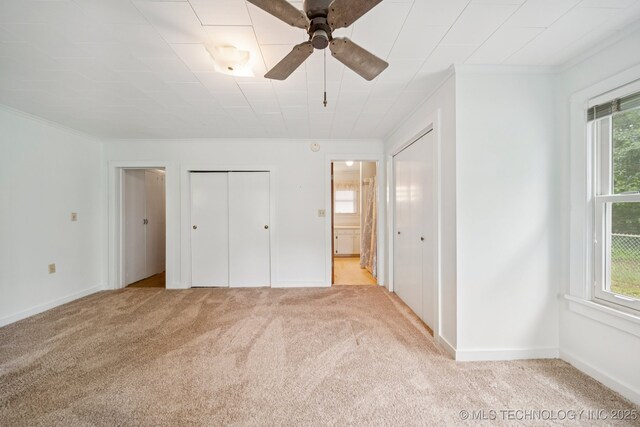 915 N Boudinot Ave, Dewey, OK 74029 - unfurnished bedroom featuring crown molding, two closets, light colored carpet, ensuite bathroom, and baseboards