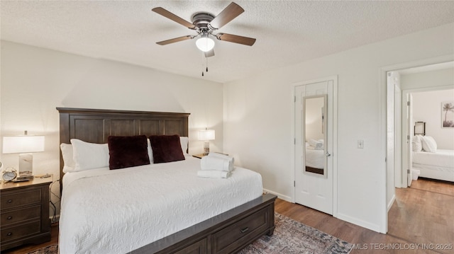 3021 S Ash Ave, Broken Arrow, OK 74012 - bedroom with wood finished floors, baseboards, a ceiling fan, and a textured ceiling