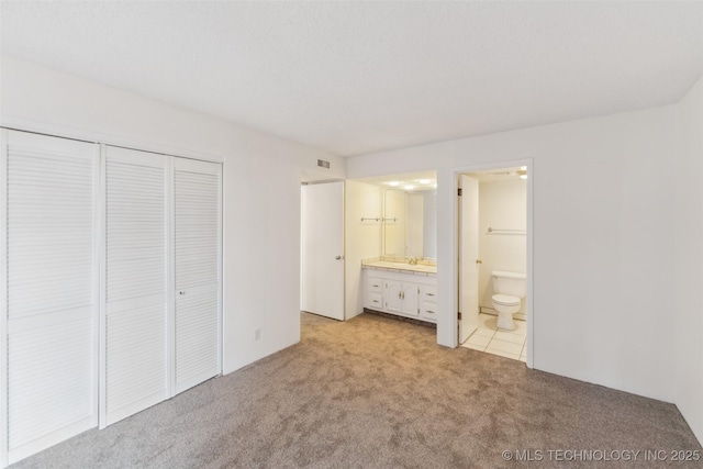 410 W 7th St Unit 241, Tulsa, OK 74119 - unfurnished bedroom with light carpet, a sink, a closet, and ensuite bathroom
