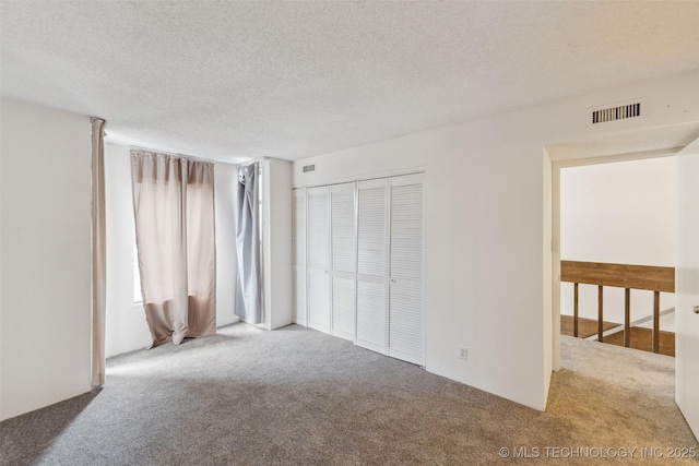 410 W 7th St Unit 241, Tulsa, OK 74119 - unfurnished bedroom featuring carpet flooring, a textured ceiling, and a closet