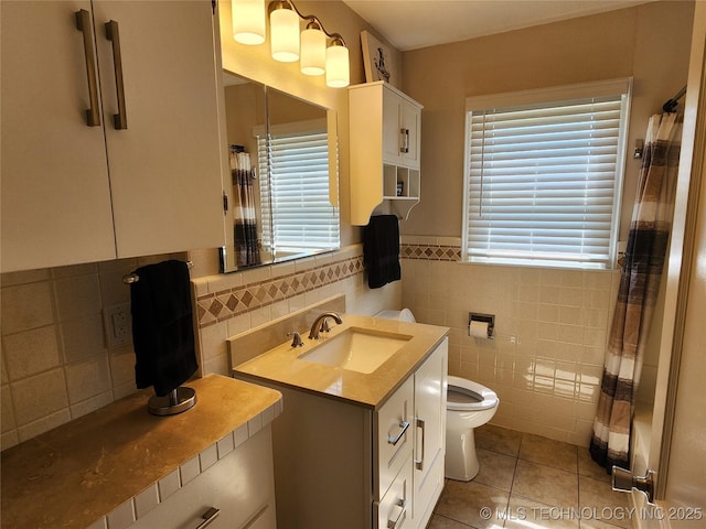 307 N W St, Mcalester, OK 74501 - bathroom with tile patterned flooring, toilet, tile walls, vanity, and healthy amount of natural light