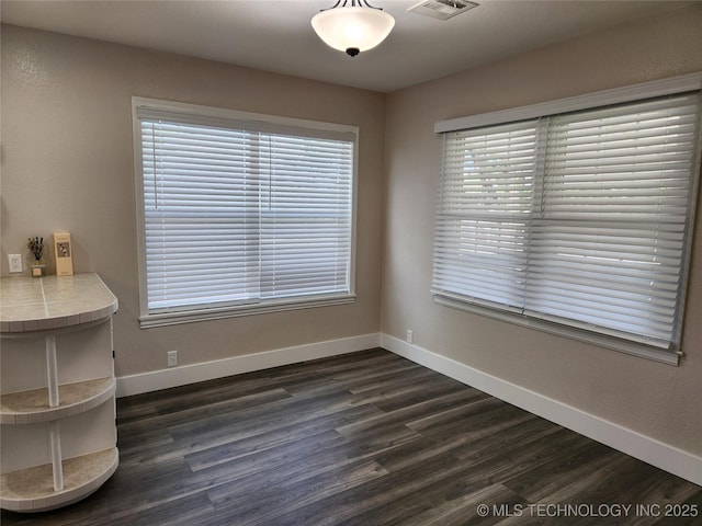 307 N W St, Mcalester, OK 74501 - unfurnished dining area featuring baseboards and dark wood-style flooring