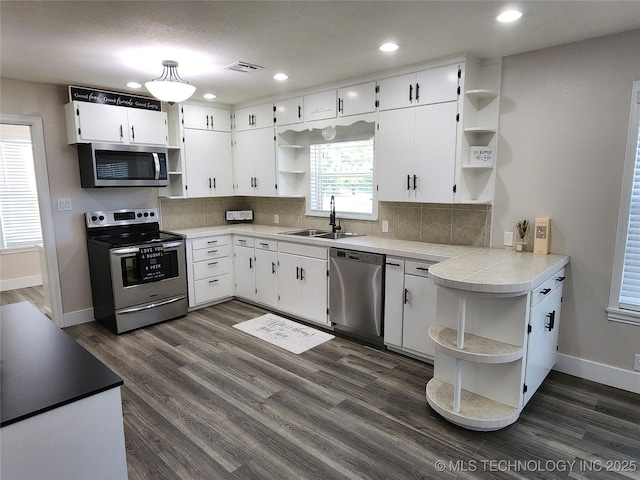 307 N W St, Mcalester, OK 74501 - kitchen with open shelves, stainless steel appliances, a sink, baseboards, and recessed lighting