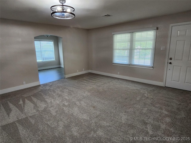 307 N W St, Mcalester, OK 74501 - empty room with carpet, arched walkways, and baseboards