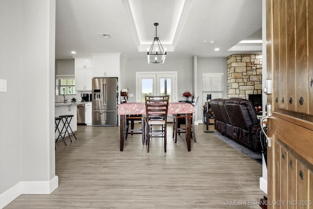 30185 N 3994th Dr, Ramona, OK 74061 - dining room with a tray ceiling, light wood-type flooring, recessed lighting, and a stone fireplace