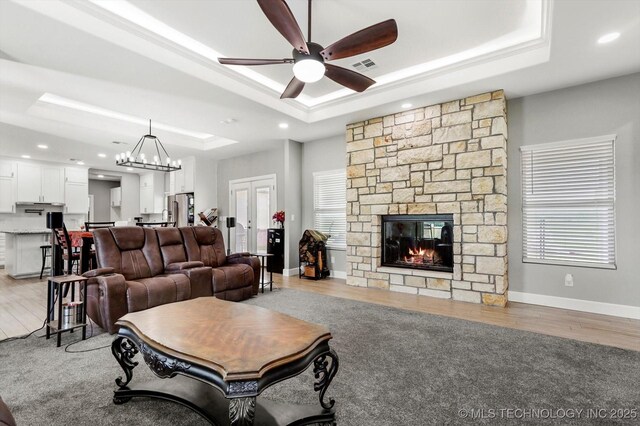 30185 N 3994th Dr, Ramona, OK 74061 - living room with a tray ceiling, a ceiling fan, a fireplace, light wood finished floors, and french doors