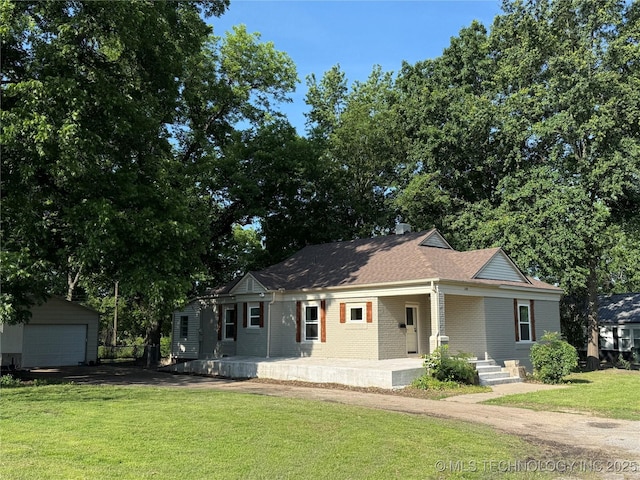 2109 Delaware St, Muskogee, OK 74403 - view of front facade featuring a porch, brick siding, a front yard, a detached garage, and an outdoor structure