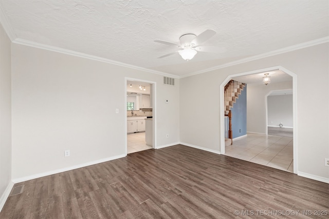 3508 Kimberlea, Muskogee, OK 74403 - spare room featuring wood finished floors, a ceiling fan, ornamental molding, a sink, and arched walkways