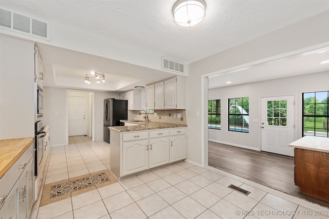 3508 Kimberlea, Muskogee, OK 74403 - kitchen featuring light tile patterned floors, a raised ceiling, stainless steel appliances, and a sink