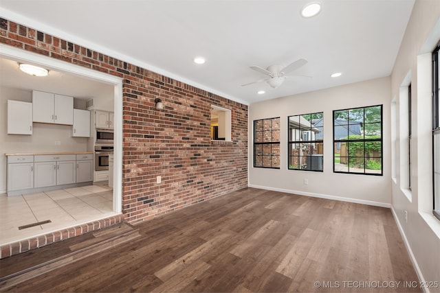 3508 Kimberlea, Muskogee, OK 74403 - unfurnished living room featuring brick wall, ceiling fan, light wood-style floors, baseboards, and recessed lighting
