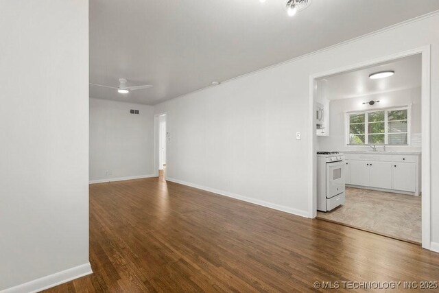 6210 E 17th St, Tulsa, OK 74112 - unfurnished room with wood finished floors, ceiling fan, a sink, baseboards, and ornamental molding