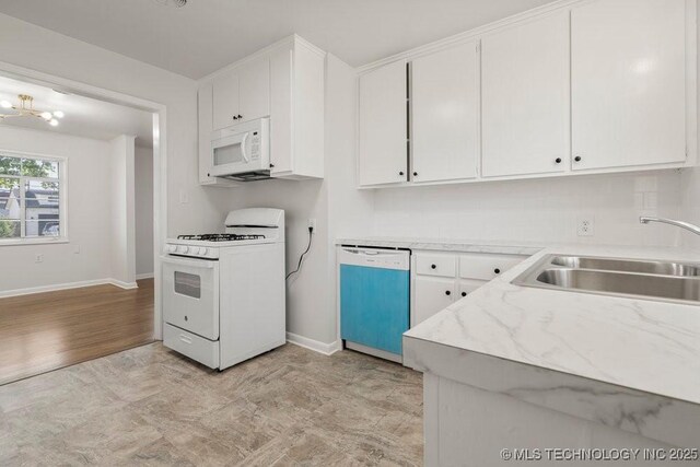 6210 E 17th St, Tulsa, OK 74112 - kitchen with white appliances, a sink, baseboards, and white cabinetry