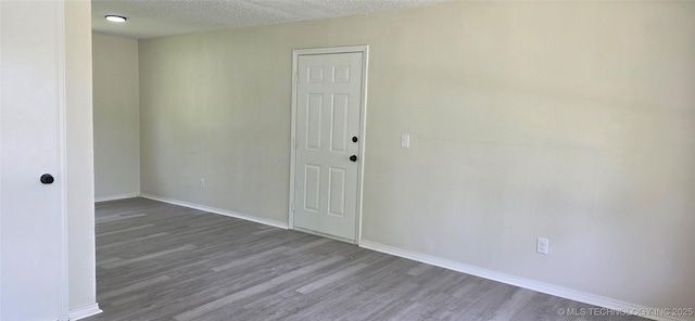1405 S Cedar St, Bristow, OK 74010 - spare room with wood finished floors, baseboards, and a textured ceiling