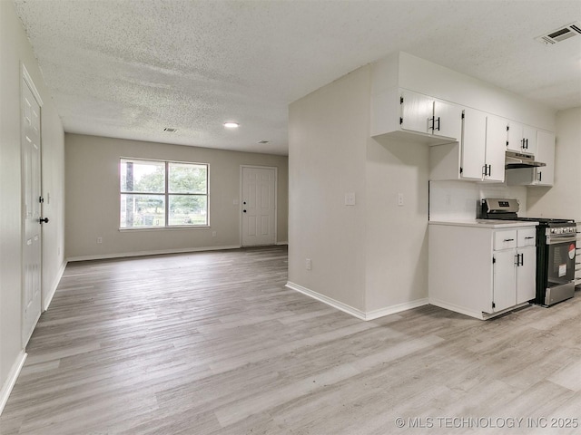 1405 S Cedar St, Bristow, OK 74010 - kitchen featuring stainless steel range with gas stovetop, under cabinet range hood, light wood finished floors, open floor plan, and a textured ceiling