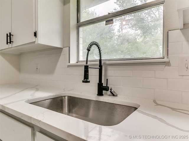 1405 S Cedar St, Bristow, OK 74010 - kitchen view of decorative backsplash, white cabinetry, and light stone countertops
