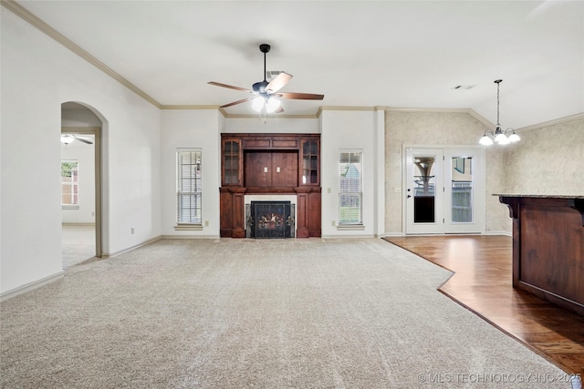 400 E Fargo St, Broken Arrow, OK 74012 - unfurnished living room with a ceiling fan, a warm lit fireplace, baseboards, arched walkways, and crown molding