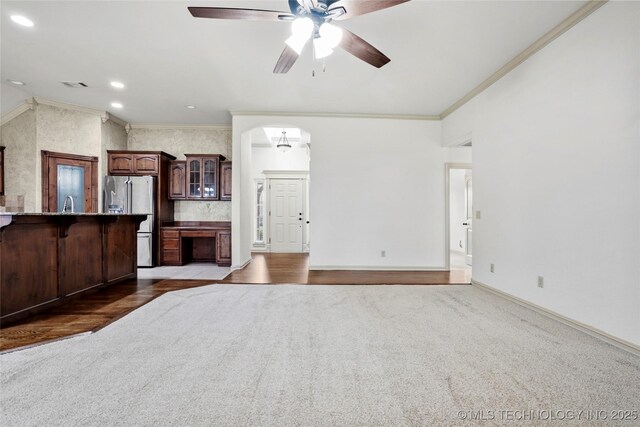 400 E Fargo St, Broken Arrow, OK 74012 - unfurnished living room with carpet floors, ornamental molding, a ceiling fan, baseboards, and arched walkways