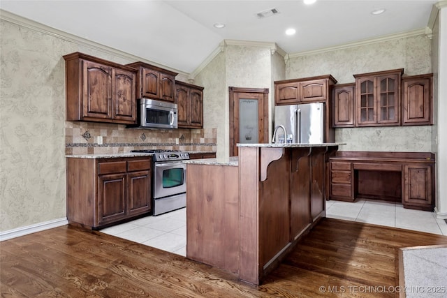 400 E Fargo St, Broken Arrow, OK 74012 - kitchen with appliances with stainless steel finishes, light wood-type flooring, crown molding, a center island with sink, and glass insert cabinets