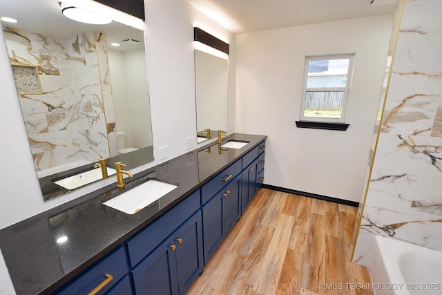 717 N Oklahoma Ave, Tahlequah, OK 74464 - full bath with wood finished floors, double vanity, and toilet