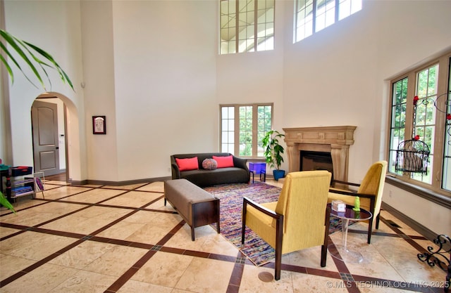 3704 River Bend Rd, Muskogee, OK 74403 - living room featuring a towering ceiling, inlaid floor details, healthy amount of natural light, and baseboards