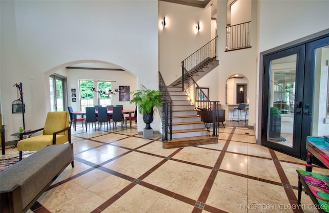 3704 River Bend Rd, Muskogee, OK 74403 - foyer with french doors, a high ceiling, arched walkways, inlaid floor details, and stairs