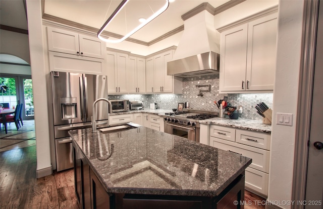 3704 River Bend Rd, Muskogee, OK 74403 - kitchen featuring appliances with stainless steel finishes, wall chimney range hood, crown molding, a sink, and dark wood-type flooring