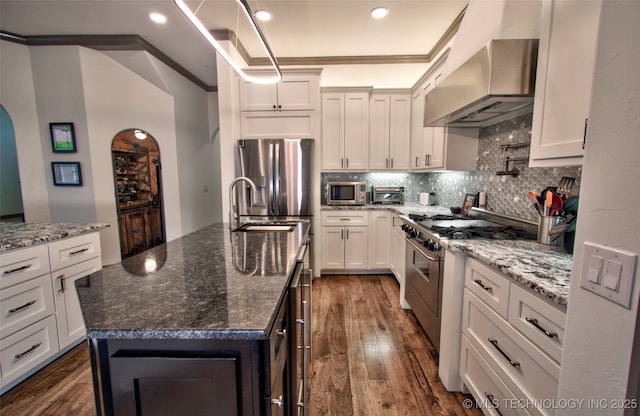 3704 River Bend Rd, Muskogee, OK 74403 - kitchen featuring wall chimney range hood, appliances with stainless steel finishes, crown molding, arched walkways, and dark wood-style flooring