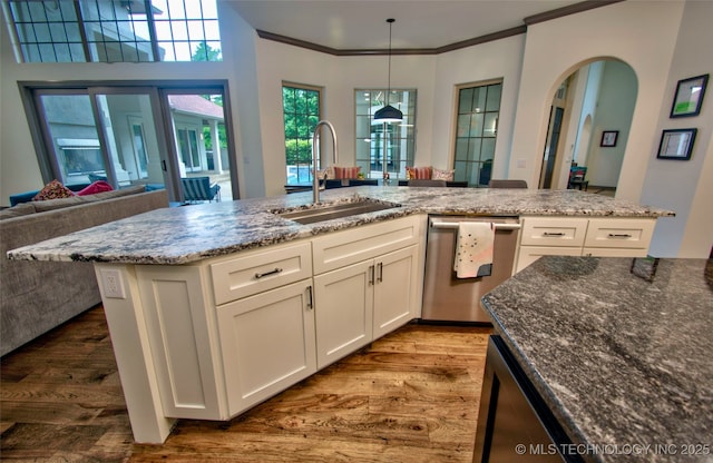 3704 River Bend Rd, Muskogee, OK 74403 - kitchen with stainless steel dishwasher, a sink, wood finished floors, dark stone counters, and white cabinets