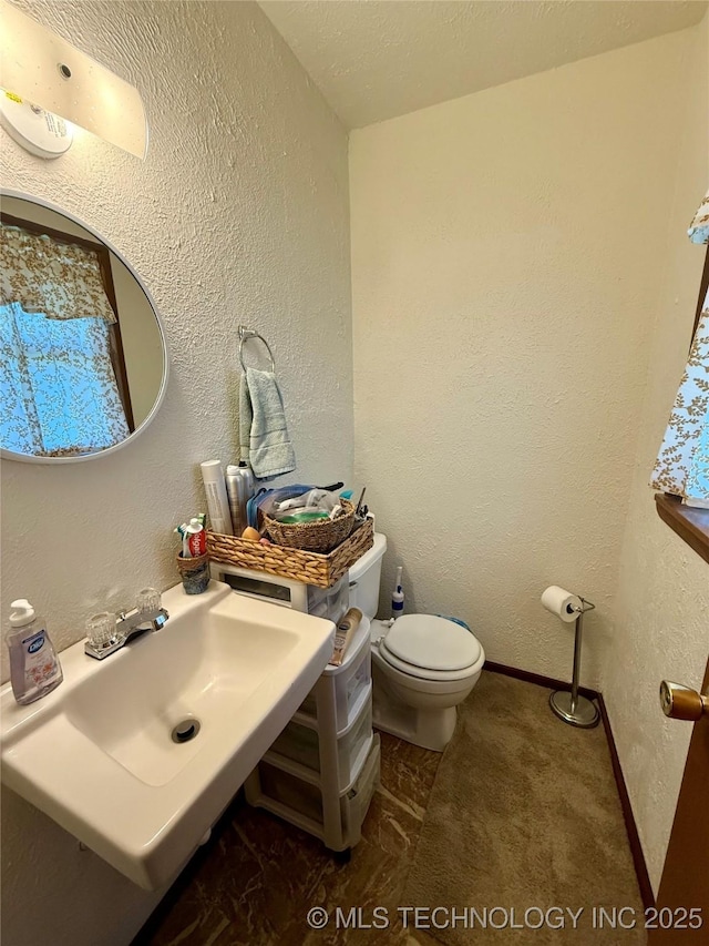 32807 S 250th Rd, Henryetta, OK 74437 - bathroom featuring toilet, baseboards, a sink, and a textured wall