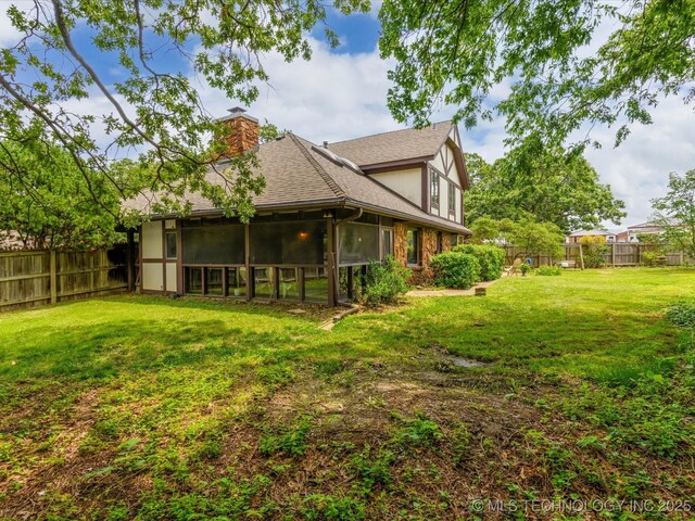 639 Oakridge Dr, Bartlesville, OK 74006 - back of property with a chimney, a shingled roof, and a sunroom