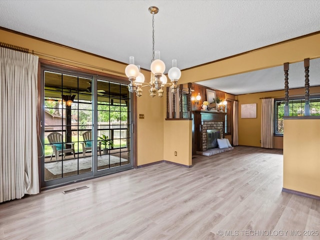639 Oakridge Dr, Bartlesville, OK 74006 - unfurnished dining area with wood finished floors, a chandelier, crown molding, a brick fireplace, and a textured ceiling