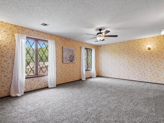 639 Oakridge Dr, Bartlesville, OK 74006 - unfurnished room with wallpapered walls, plenty of natural light, carpet, ceiling fan, and a textured ceiling