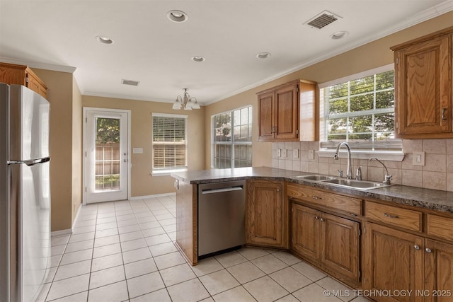 3713 S Poplar Ave, Broken Arrow, OK 74011 - kitchen with stainless steel appliances, a sink, brown cabinets, a chandelier, and dark countertops
