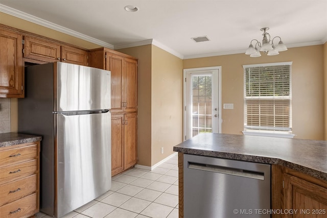 3713 S Poplar Ave, Broken Arrow, OK 74011 - kitchen featuring stainless steel appliances, dark countertops, a chandelier, brown cabinets, and ornamental molding