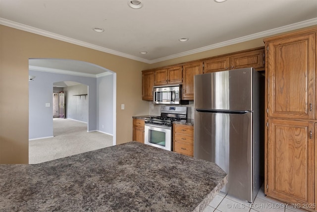 3713 S Poplar Ave, Broken Arrow, OK 74011 - kitchen featuring appliances with stainless steel finishes, arched walkways, brown cabinets, crown molding, and recessed lighting