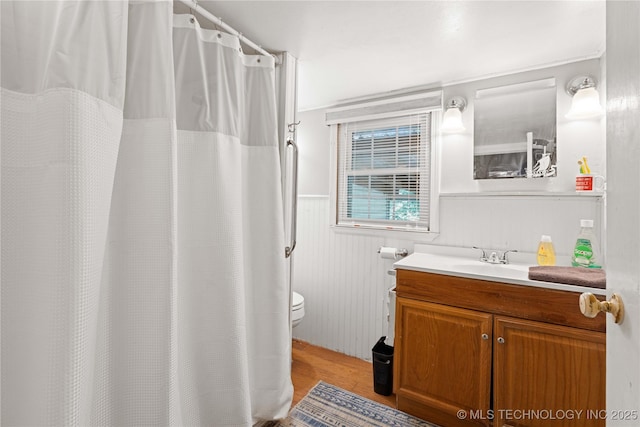 800 N Hwy 10, Gore, OK 74435 - full bathroom featuring toilet, wood finished floors, vanity, a wainscoted wall, and a shower with shower curtain