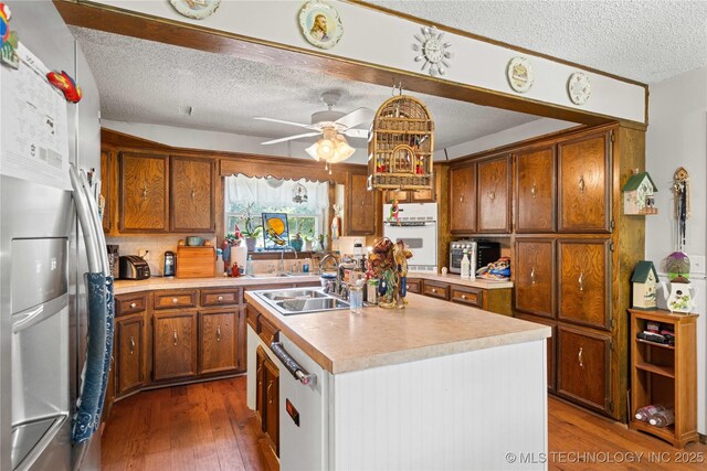 800 N Hwy 10, Gore, OK 74435 - kitchen featuring stainless steel refrigerator with ice dispenser, a textured ceiling, a sink, dark wood-style floors, and light countertops