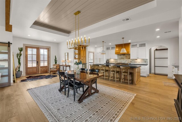 35795 E 231st St S, Porter, OK 74454 - dining area featuring arched walkways, a raised ceiling, light wood-type flooring, recessed lighting, and french doors