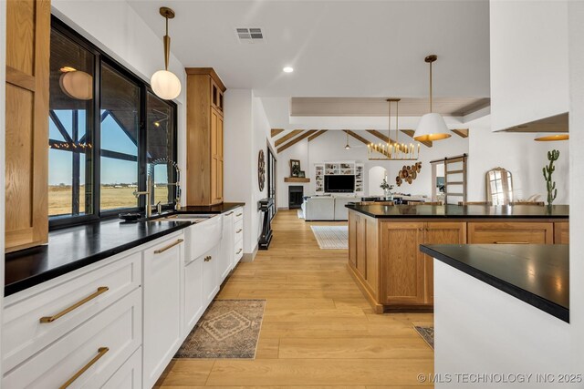 35795 E 231st St S, Porter, OK 74454 - kitchen featuring dark countertops, open floor plan, pendant lighting, light wood-style floors, and a peninsula