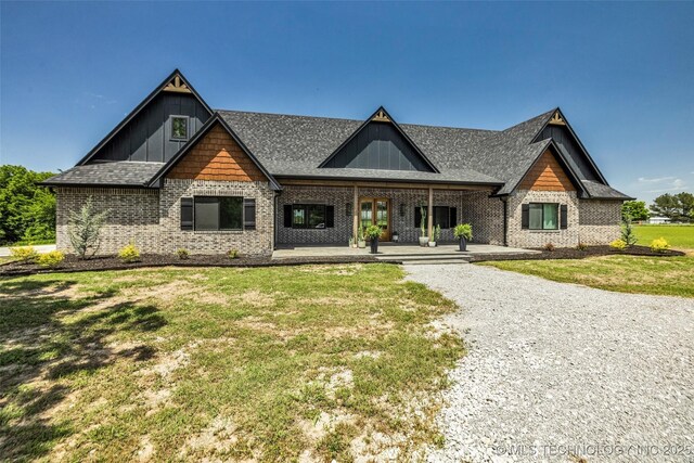 35795 E 231st St S, Porter, OK 74454 - view of front of home with a front lawn, brick siding, a shingled roof, and board and batten siding