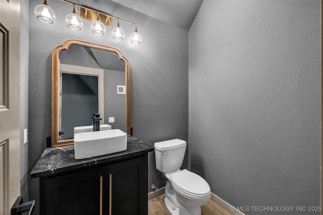 35795 E 231st St S, Porter, OK 74454 - half bath with wood finished floors, vanity, toilet, a textured wall, and baseboards